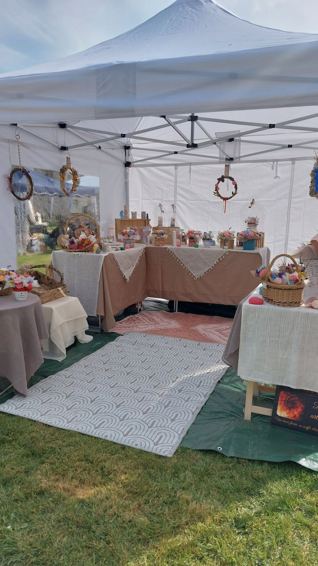 Le stand À fleur de flamme installé sous un barnum lors d'un marché de créateurs
